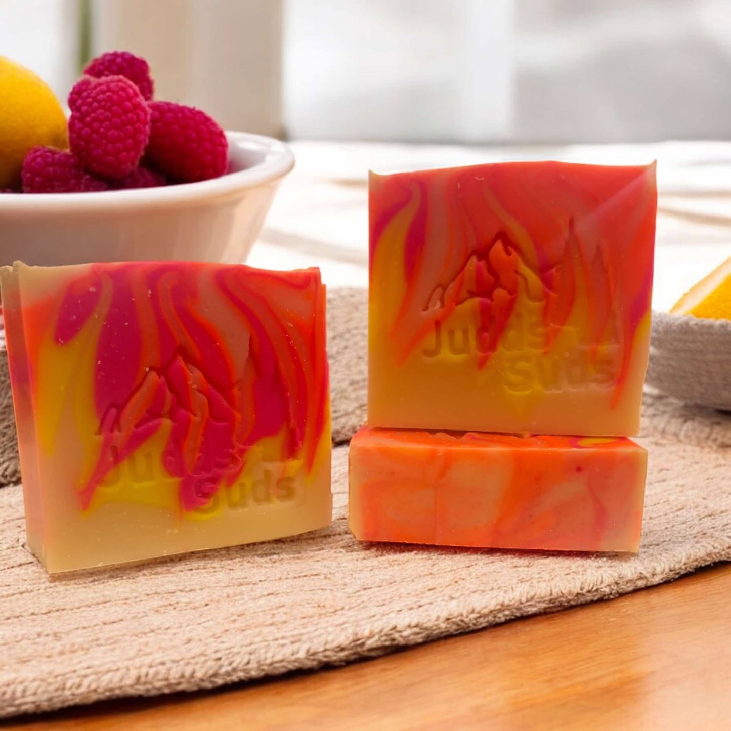 4oz soap bar, colored with pink, orange and yellow, scented with raspberry lemonade fragrance oil