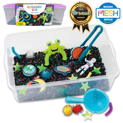 Alien sensory bin, contains space rocks, astronaut toy, squishy alien, foam planets, sparkly pom poms, tongs, spirals, glow in the dark stars, and scoop.