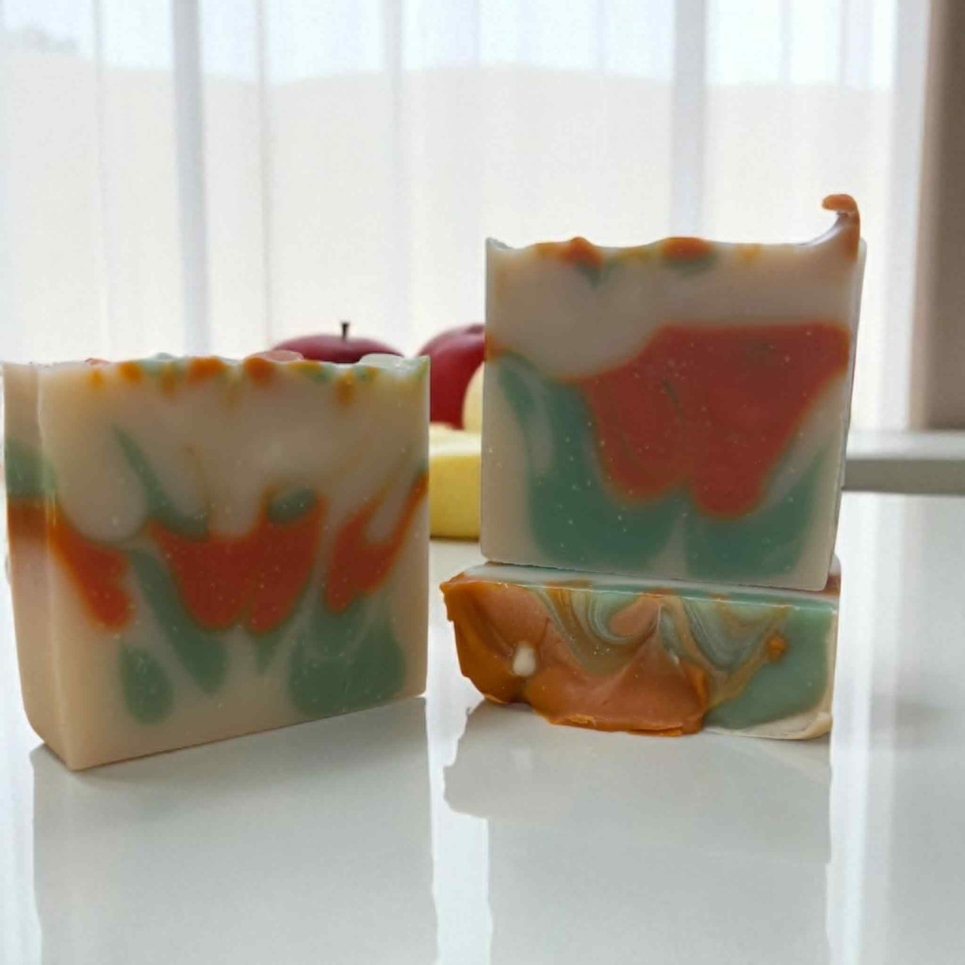Colorful marbled soap bars on a white surface with a blurred background