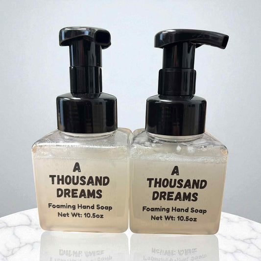 Two bottles of 'A Thousand Dreams' foaming hand soap on a light background