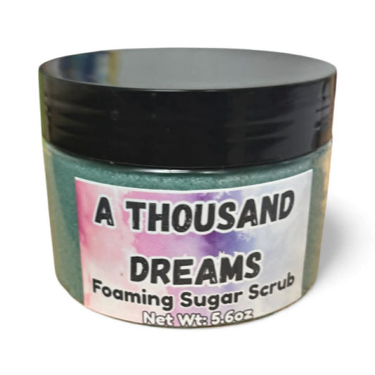 Jar of 'A Thousand Dreams' foaming sugar scrub with a colorful label.