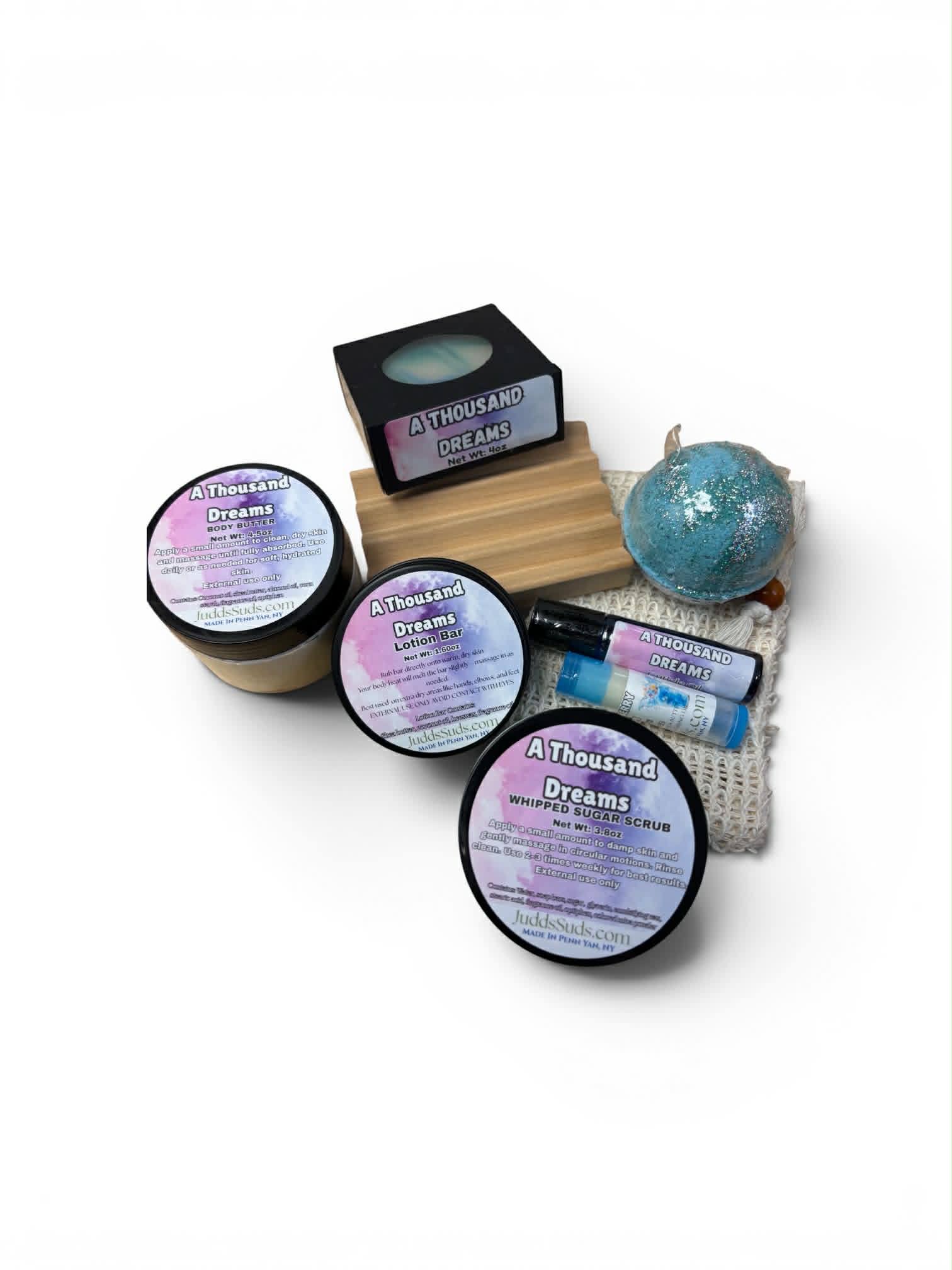 Collection of 'A Thousand Dreams' products including jars, a bar of soap, and a bath bomb on a white background.
