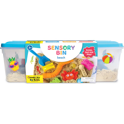 Sensory bin packaging with beach-themed toys and sand on a white background