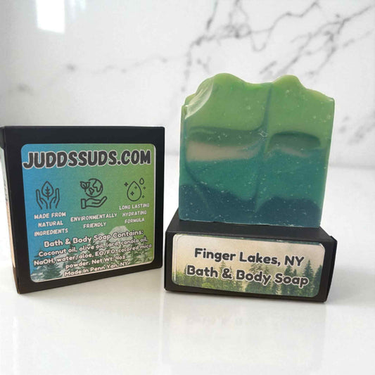 Green bath and body soap with a label on a white surface