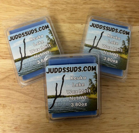 Three packages of JuddsSuds Keuka Lake Wax Melt on a wooden surface