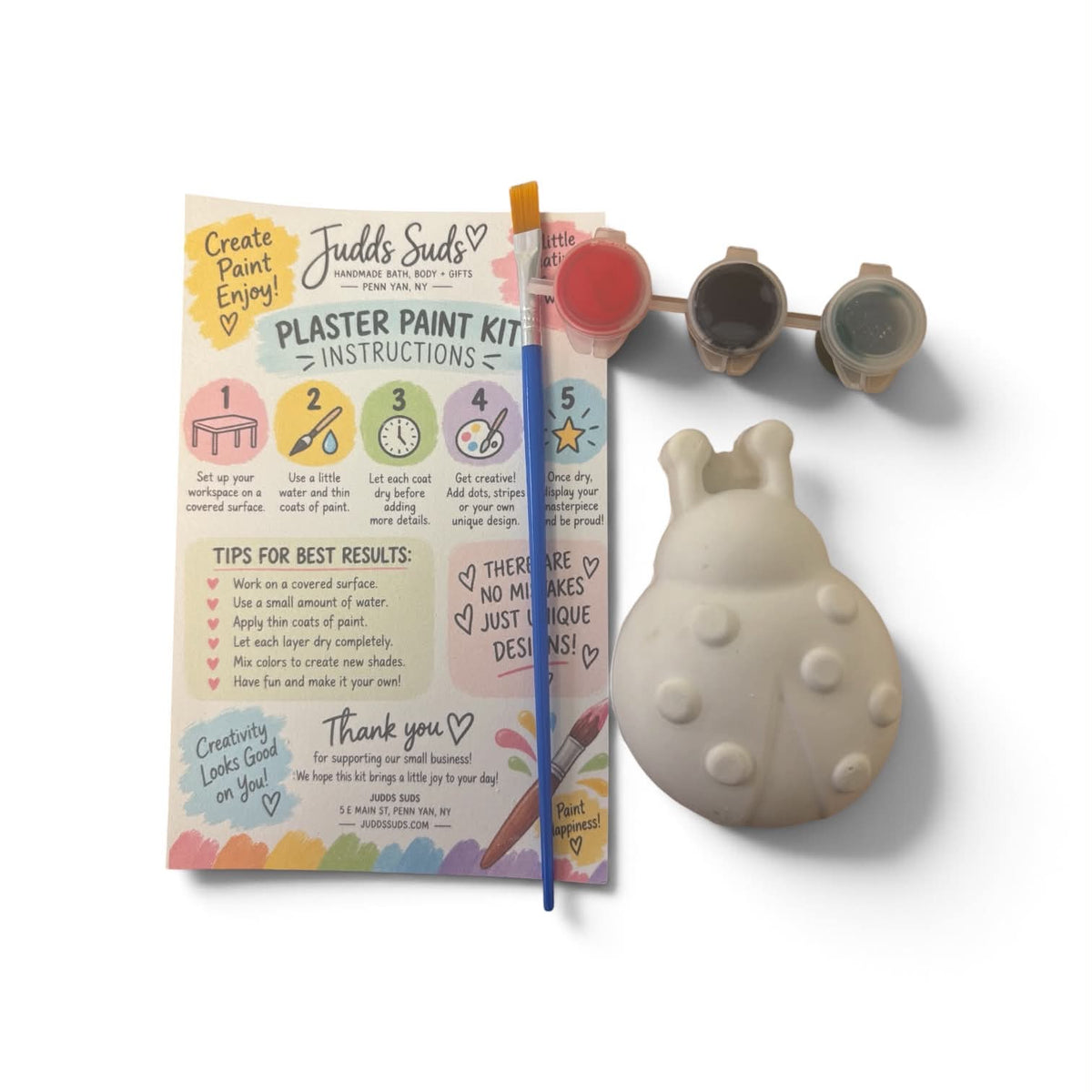 Judd's Judds Plaster Paint Kit shown with its instruction booklet, paintbrush, three small paint cups, and a beige bunny-shaped plaster mold on a white background.