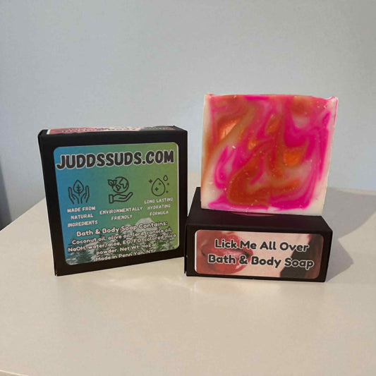 Bar of soap with pink and orange swirls next to a black box labeled 'JUDDSSUDS.COM' on a white surface.