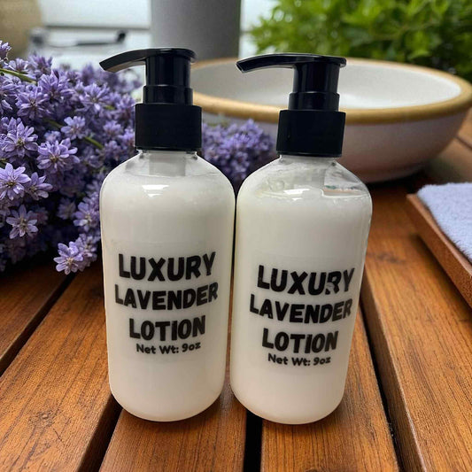 Two bottles of luxury lavender lotion on a wooden surface with flowers in the background.
