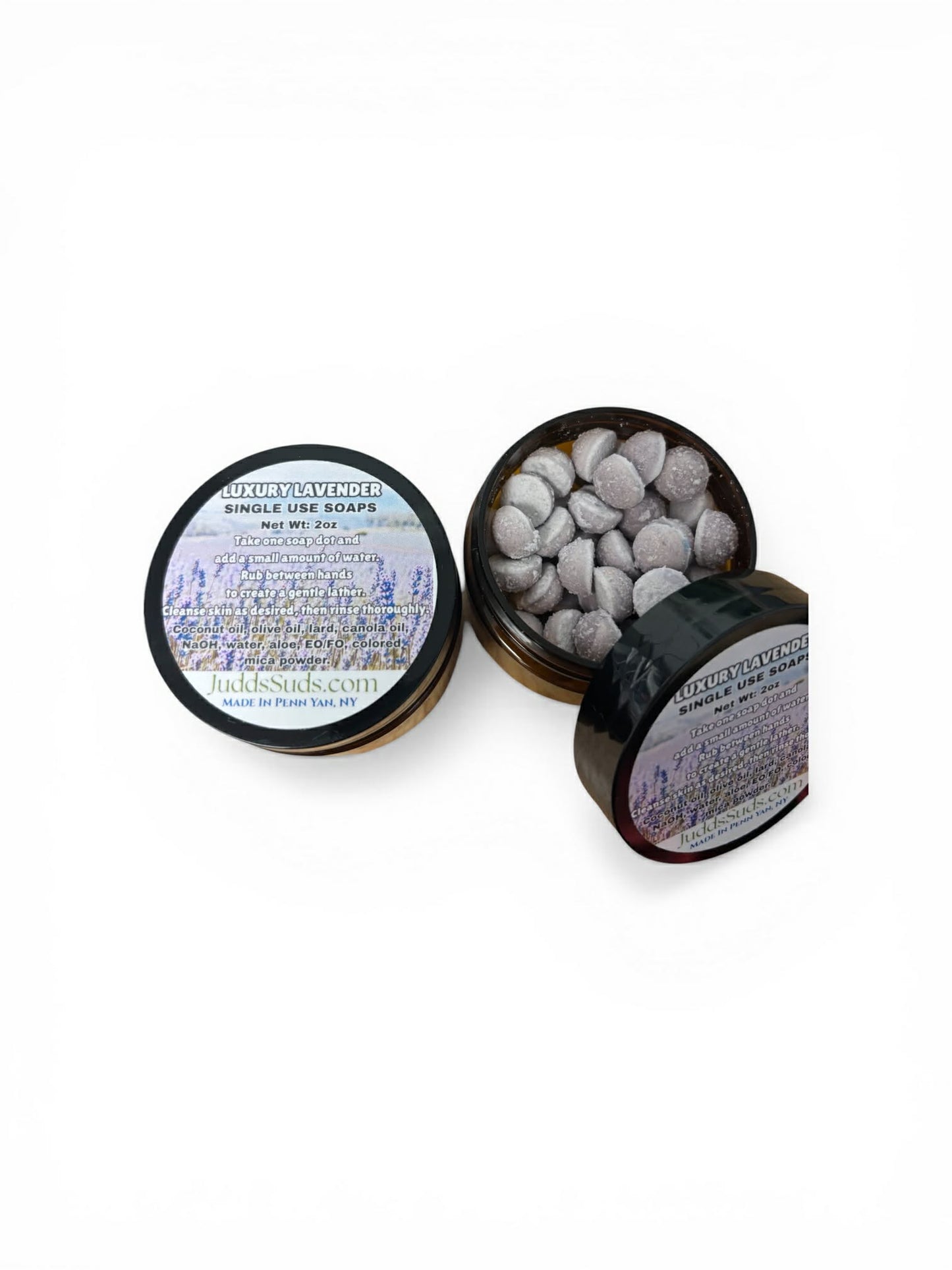 Black container with single-use soap balls and label on a white background