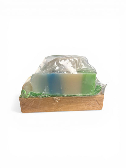 Bar of soap on a wooden soap dish with clear plastic cover on a white background