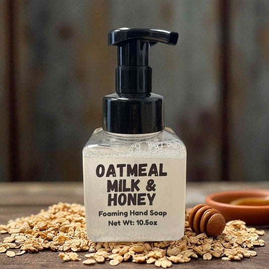 Oatmeal Milk & Honey foaming hand soap bottle with ingredients on a wooden surface
