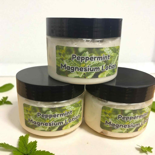 Three jars of peppermint magnesium lotion stacked on a white background with peppermint leaves.