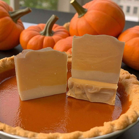 Three bars of soap with a pumpkin pie and pumpkins in the background