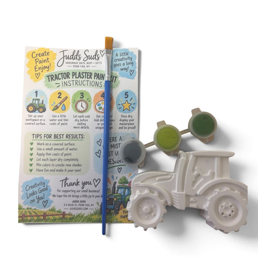 A children's paint-by-numbers tractor kit shown on a white background, including a printed instruction booklet, a paint palette with green and blue paint cups, a blue paintbrush, and a gray plastic tractor mold.